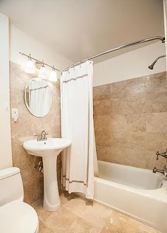 Newly renovated bathroom with tiled floors and walls
