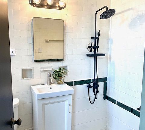 Private bathroom off primary bedroom features custom tiled shower.