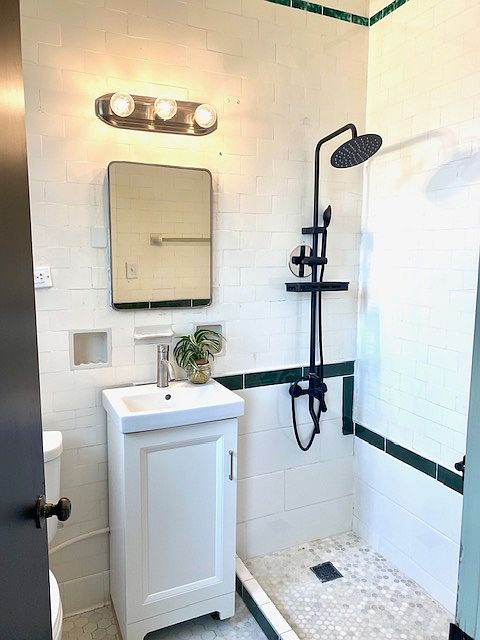 Private bathroom off primary bedroom features custom tiled shower.