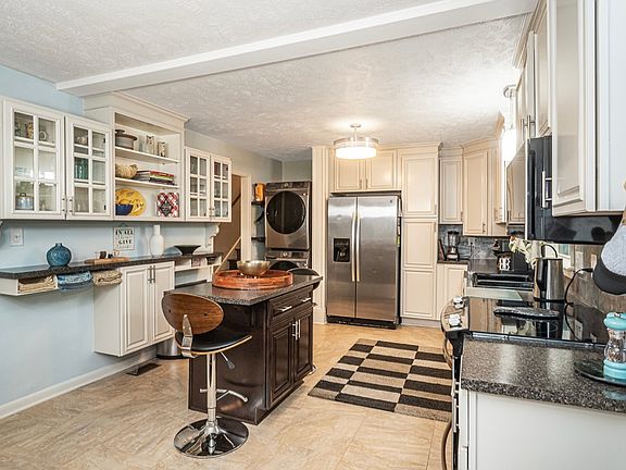 Beautiful, completely updated kitchen is fully stocked; island with two barstools, LG stacked washer and dryer