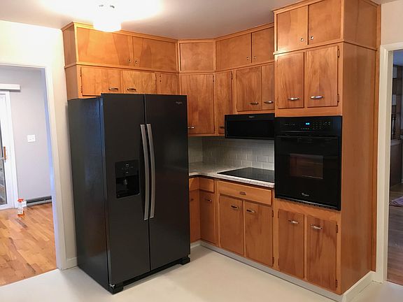 Black stainless refrigerator, stove top, built in oven and microwave. Original 1960s Cabinets