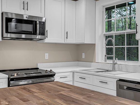 Stainless steel appliances. Maple Butcher block counter top for Island and quartz countertops.