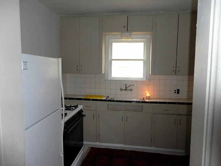 Small vintage kitchen with laundry room adjacent.