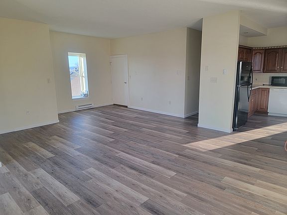 Walking across the open floor plan looking back to the front entry door. Rear entry door is unseen.