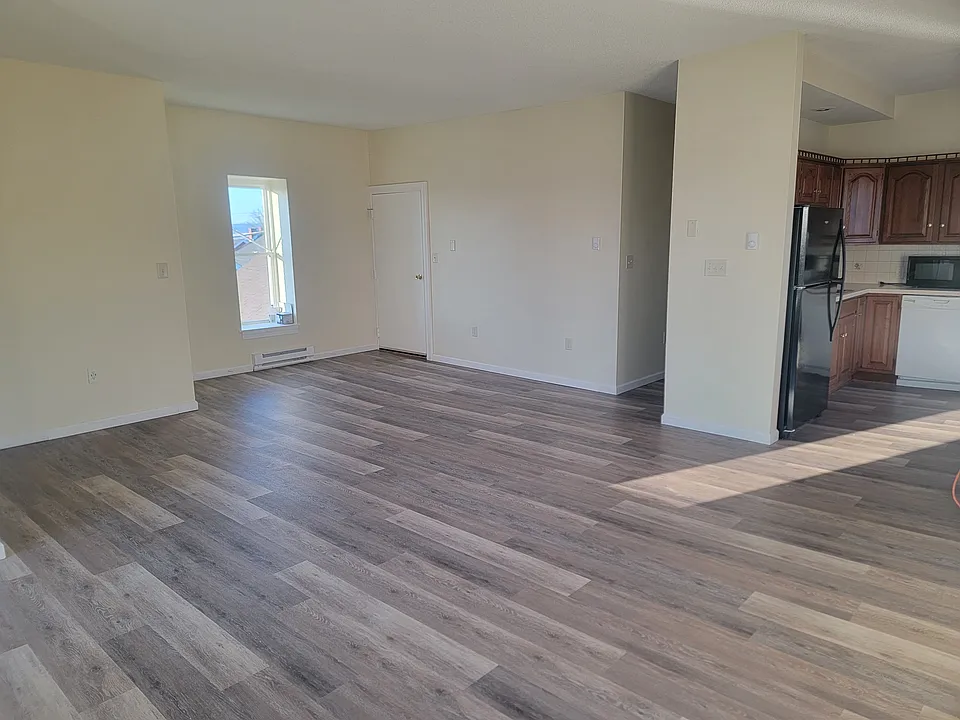 Walking across the open floor plan looking back to the front entry door. Rear entry door is unseen.