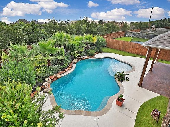 This one story beauty has a tropical oasis for a back yard with sparkling pool, ample covered space, lush landscaping and no rear neighbors!