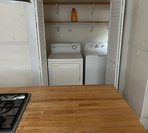 utility area with washer and dryer off kitchen.