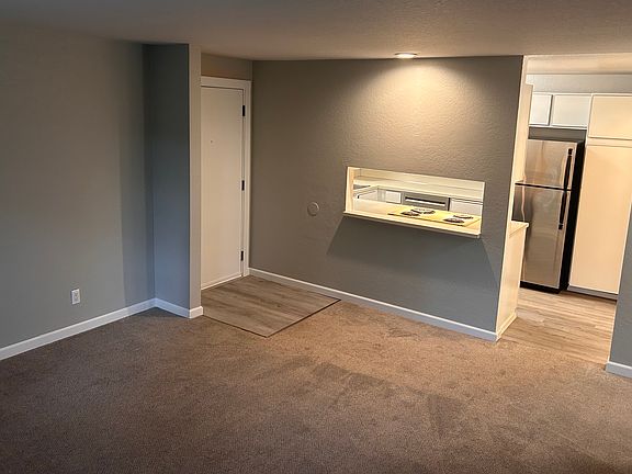 Living Room showing front door and entry to kitchen with pass through.