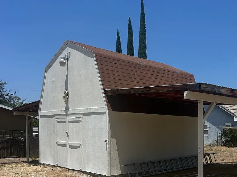 picture of small barn with two parking spaces in back yard