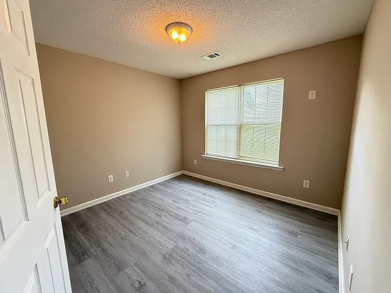 Comfortable third bedroom beautifully detailed with brand-new flooring and a large window