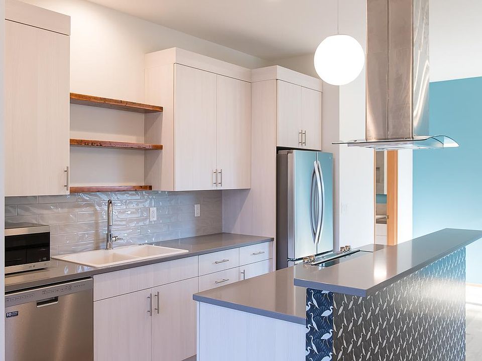Kitchen with stainless steel appliances: electric ranger, dishwasher, fridge and microwave.