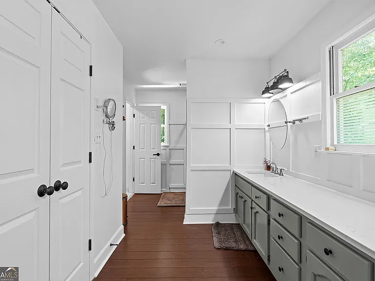Master bath with double vanity, walk-in closet (doors to the left), and large shower