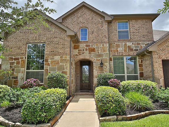 This home has a pretty brick and stone exterior, mature trees and lush landscaping with great curb appeal!