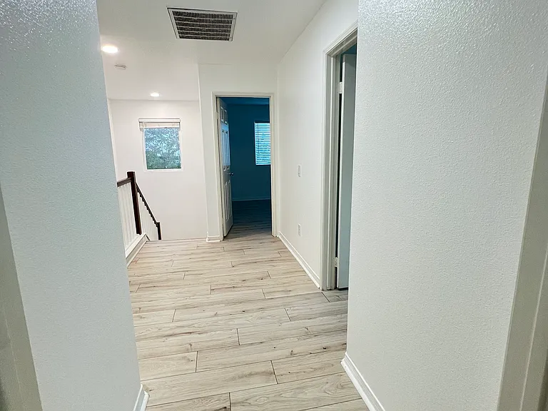 View from primary bedroom to hallway that leads to bedrooms 1 and 2.