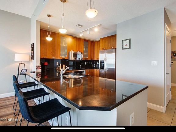 Condo kitchen complete with stainless steel Kitchenaid stove, refrigerator, microwave and dishwasher