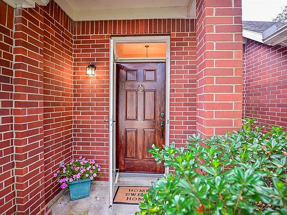 Meander up to a covered patio, that leads to a storm door and classic wood door that allows you a pathway to entry into the home!