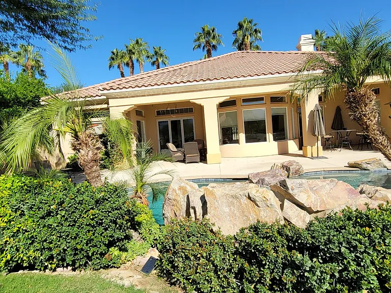 Green grass area on the backside of the pool, view of the golf course and beautiful mountains.