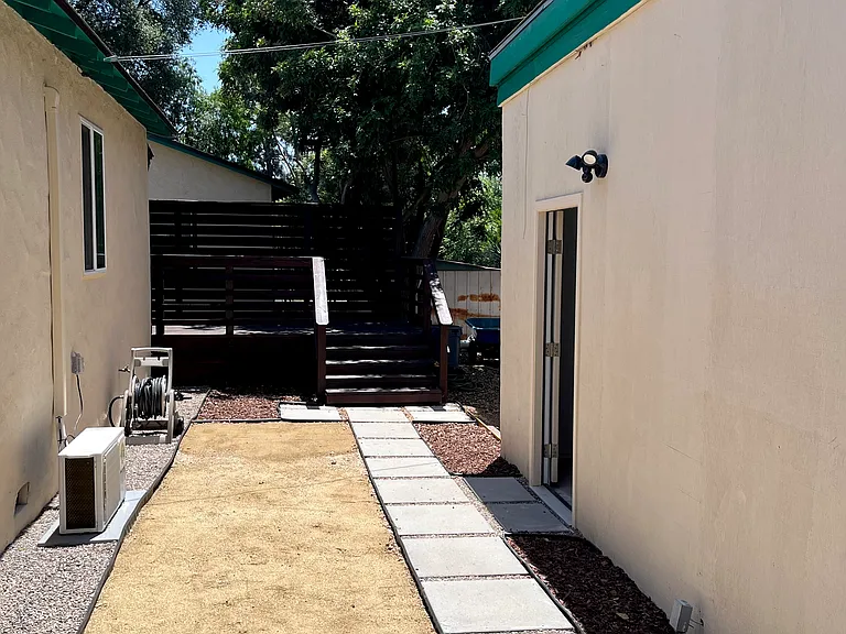 Sunlit backyard with private serenity.
Storage/craft units on right, home on left.
