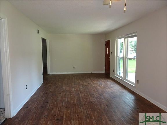 Large living room with vinyl plank flooring and double paned windows