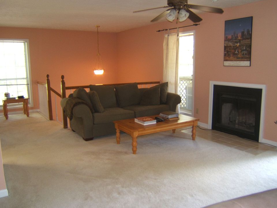 Open, bright living room with fireplace & doors to deck