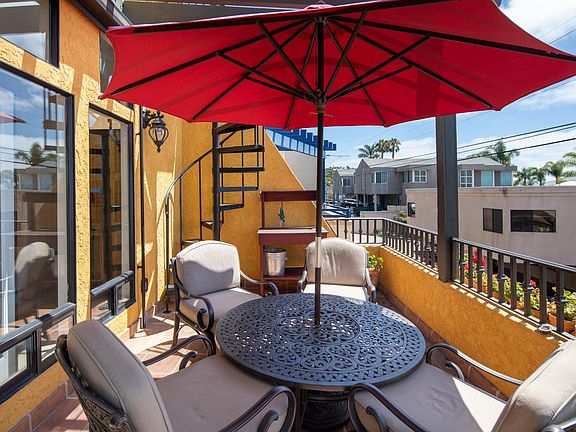 RELAXING PATIO AREA OFF THE FAMILY ROOM. THE STAIRCASE LEADS UP THE ROOFTOP PATIO WITH SEATING AREA AND BBQ