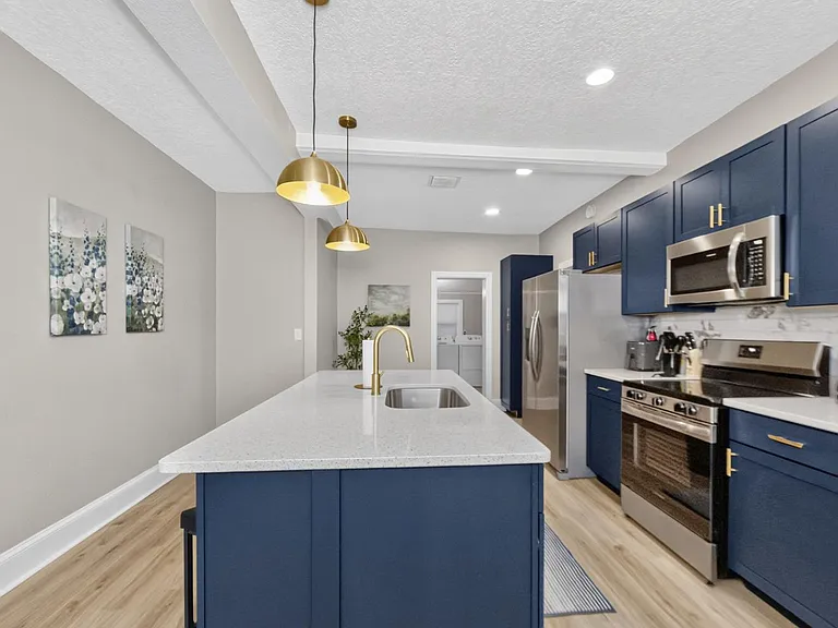 Spacious kitchen with a large island sink, stainless-steel appliances, and generous cabinetry for everyday storage.
