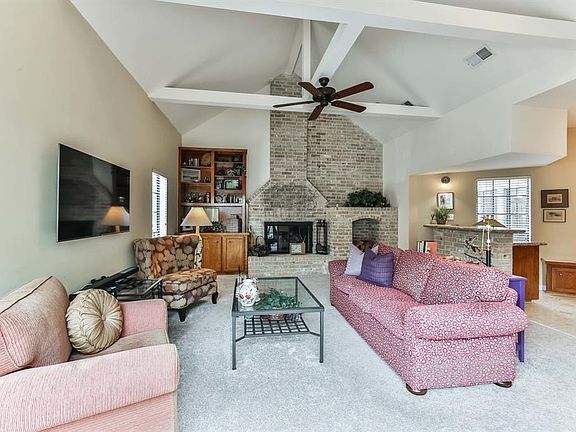 The very spacious living room has carpet floors, high ceilings and an updated ceiling fan.