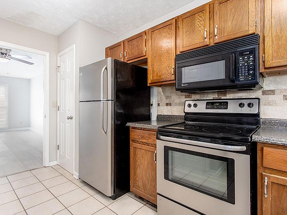 Stainless fridge, tile floor, pantry, tile backsplash