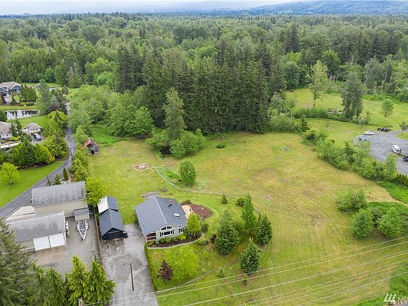Great level sunny pasture area with small pond, wooded area at back of property has trails and large evergreen trees for exploring.