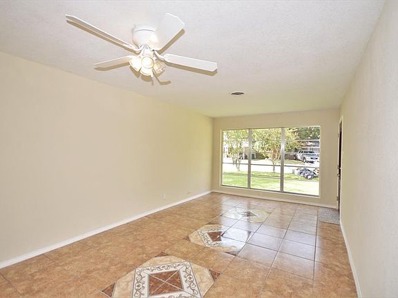 SPACIOUS LIVING AREA WITH NATURAL SUNLIGHT AND CEILING FAN