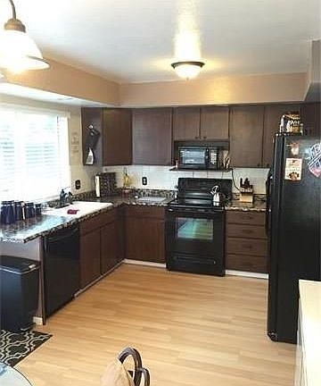Kitchen with hardwood floor and all appliances