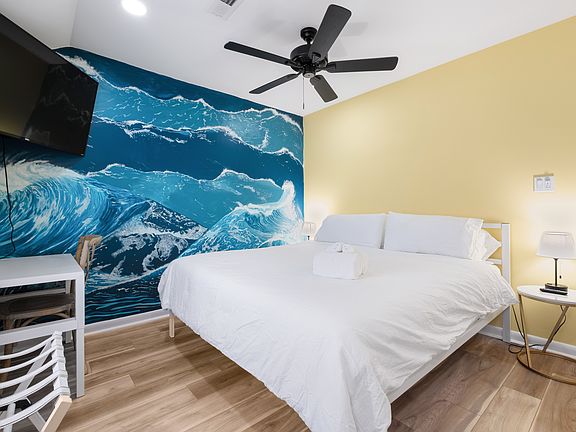 Bedroom easily fits a king size bed (pictured) and features a wave mural by local artists Amanda Auble.