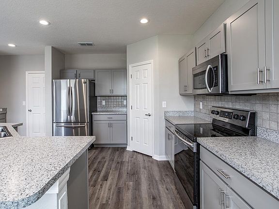 Open kitchen with counter-height island, walk--in pantry, and your choice of finishes - Sydney by Hi