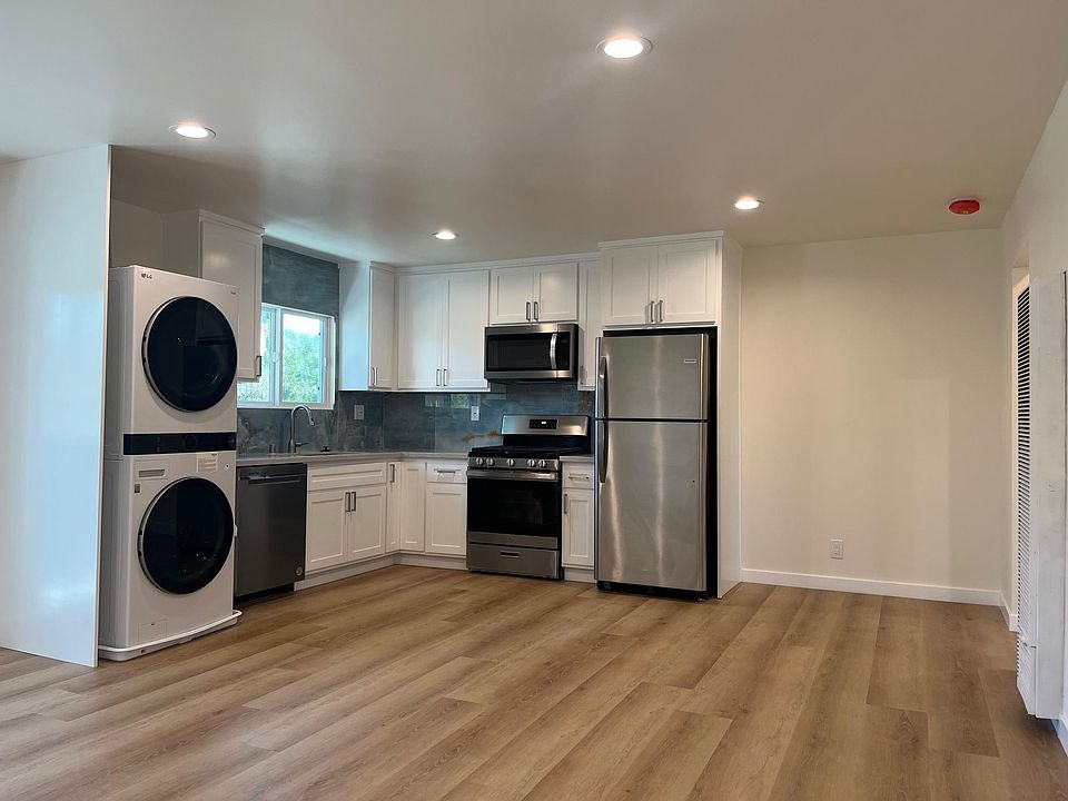 Open concept kitchen with stainless-steel appliances and laundry