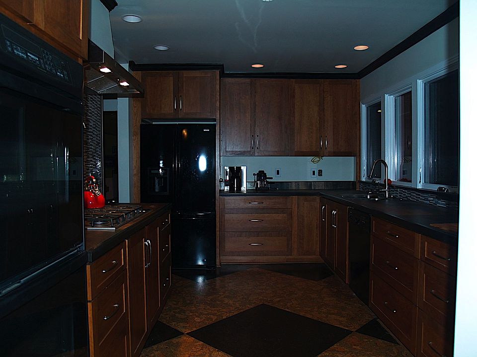 Long view of kitchen with all appliances and surfaces in view.  Kitchen is a g