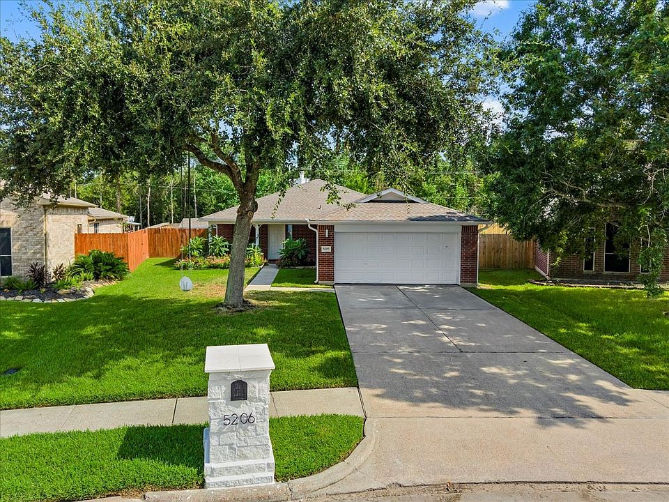 Charming single-story home with a neatly maintained front yard and mature trees. Features a two-car garage and a spacious driveway. The house has a brick exterior and a welcoming front entrance. Ideal for comfortable suburban living.