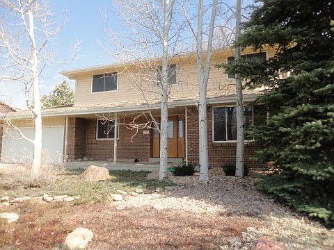 Front of home staged by trees.