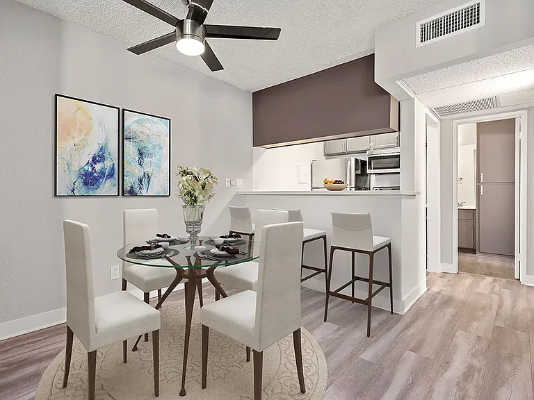 Dining room with view of ceiling fan and bar seating in kitchen.