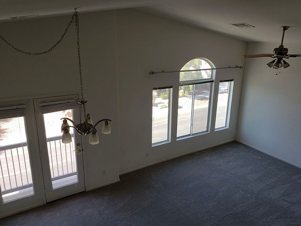 Spacious living room and dining room with high ceilings and balcony. Note: living room has a ceiling fan and updated lighting fixtures not depicted in photos.
