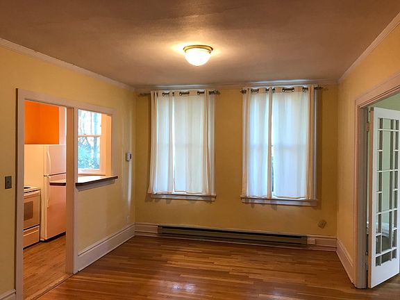 Corner unit featuring large windows on two sides, all facing neighbor's yard and trees.