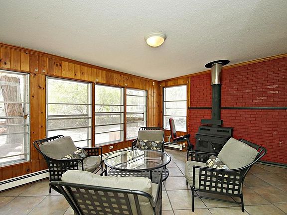 Four season porch with wood burning stove and tile floors.