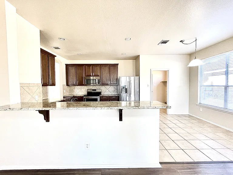 Large kitchen open kitchen, with ample storage and counter space, comes with full stainless steel appliance package, and a breakfast bar
