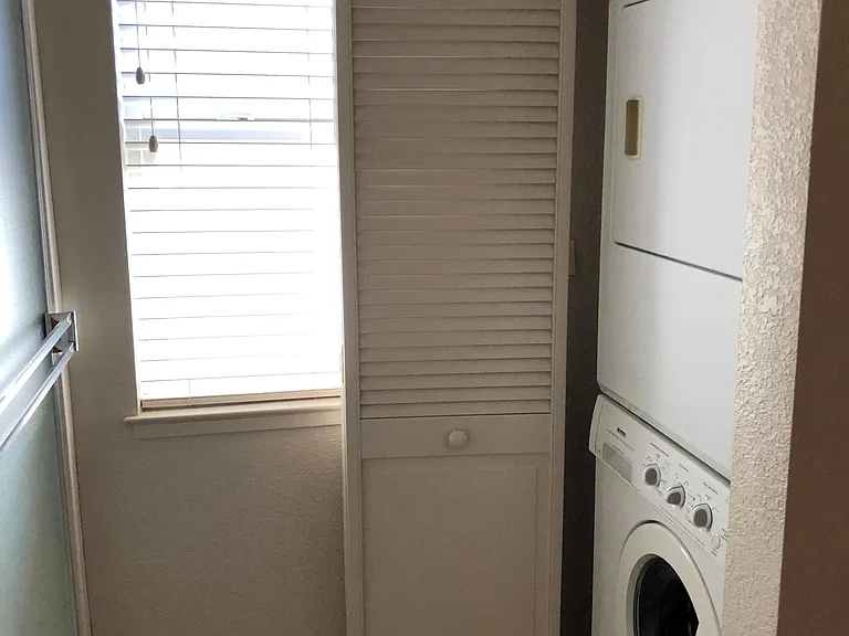 Washer/dryer is hidden behind louvered doors when not in use.