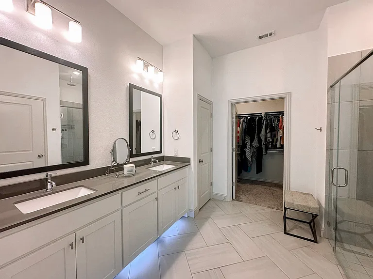 Primary bathroom is a retreat with it's double vanity, ADA compliant shower with rainhead