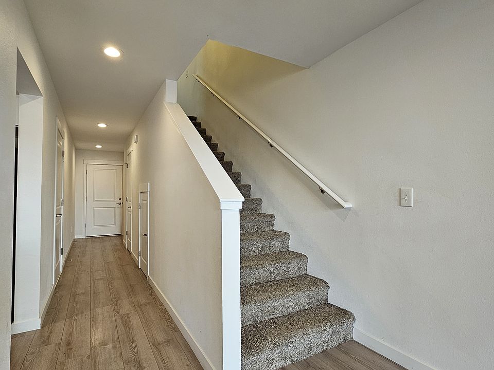 View of the hallway to the front door, and the stairs to the second floor.