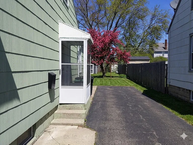 Enclosed side entrance, driveway parking (no garage).