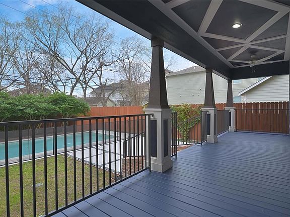 Great room and kitchen lead out to the beautifully designed backyard boasting green space, patio, and covered living area.