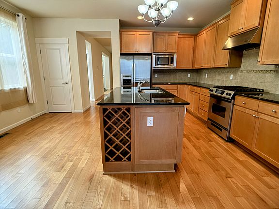 Beautiful upscale kitchen. Stainless steel appliances. Door to the pantry. Breakfast nook. Rack for wine bottles or other bottles.
