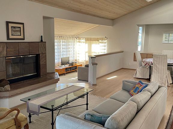 Living room with working fireplace, sunken reading/TV/yoga room in back left of picture. House offered furnished or non-furnished.