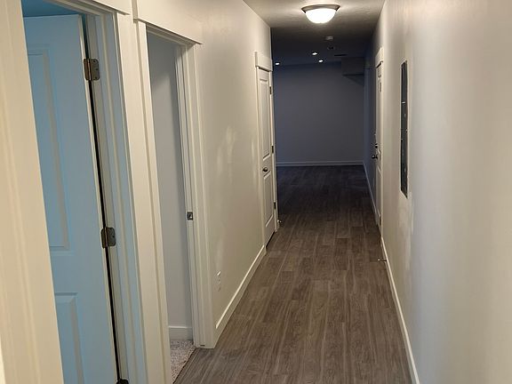 from bathroom with bedroom doors to the left and hallway towards kitchen